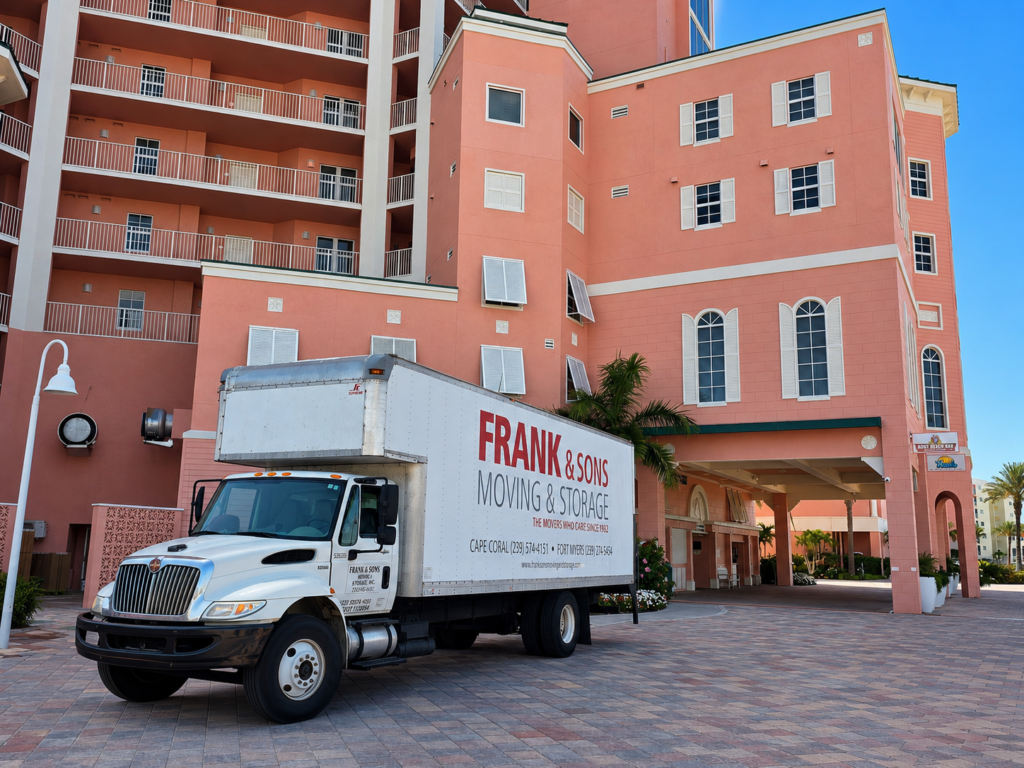 Frank & Sons moving truck parked beside a multi-story condominium building