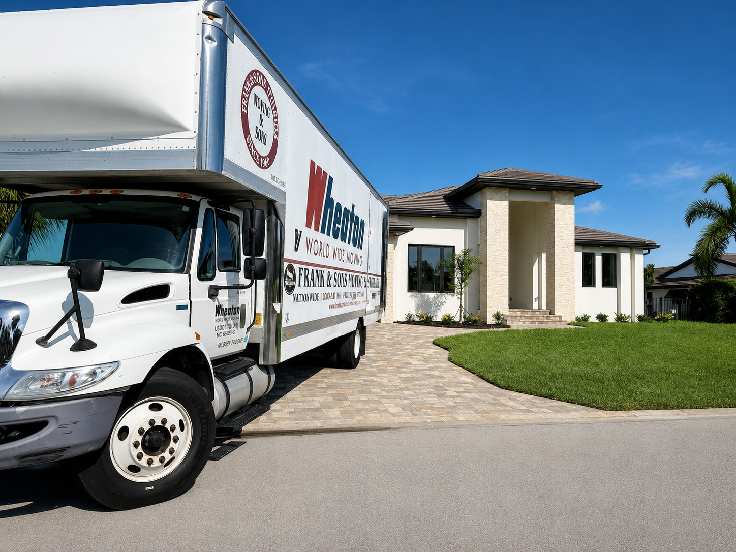 Frank & Sons moving truck parked on a driveway outside a home